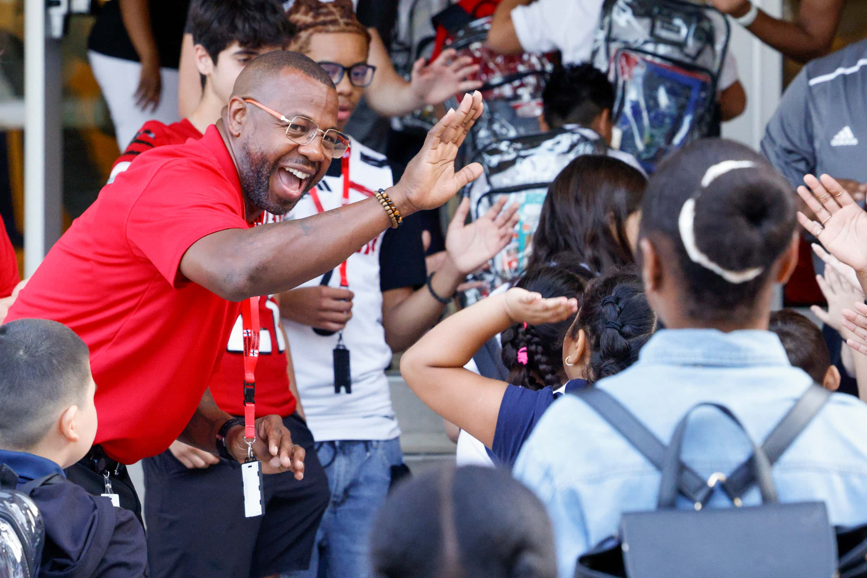 Hillcrest High School boys basketball coach Kelan Jones high-fives students as they walk in...