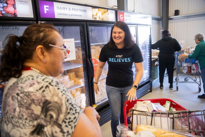 Volunteer Veronica Linthicum helps a neighbor find items at the food pantry at CitySquare...