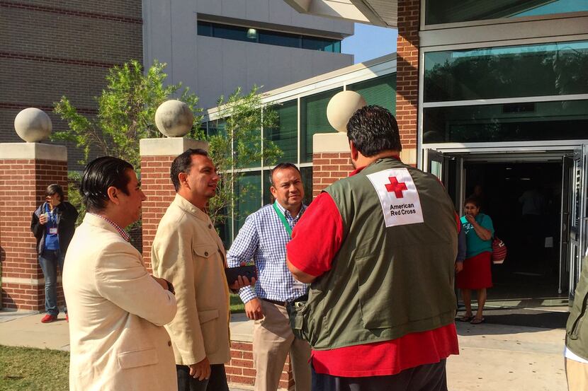 Mexican consular staff discuss immigrant evacuees with a Red Cross worker at the shelter at...