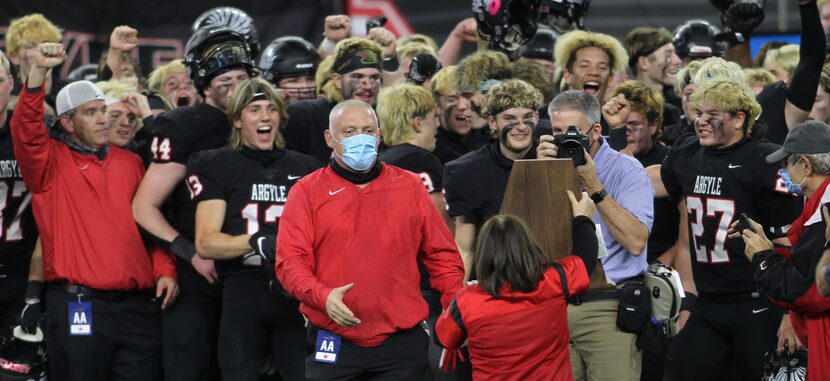 Argyle head coach Todd Rodgers steps up to accept the state championship trophy as his...