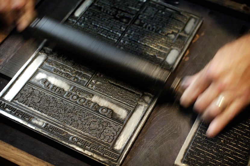 Rusty Maisel rolls ink onto a plate while operating a replica of the Gutenberg Press at the...