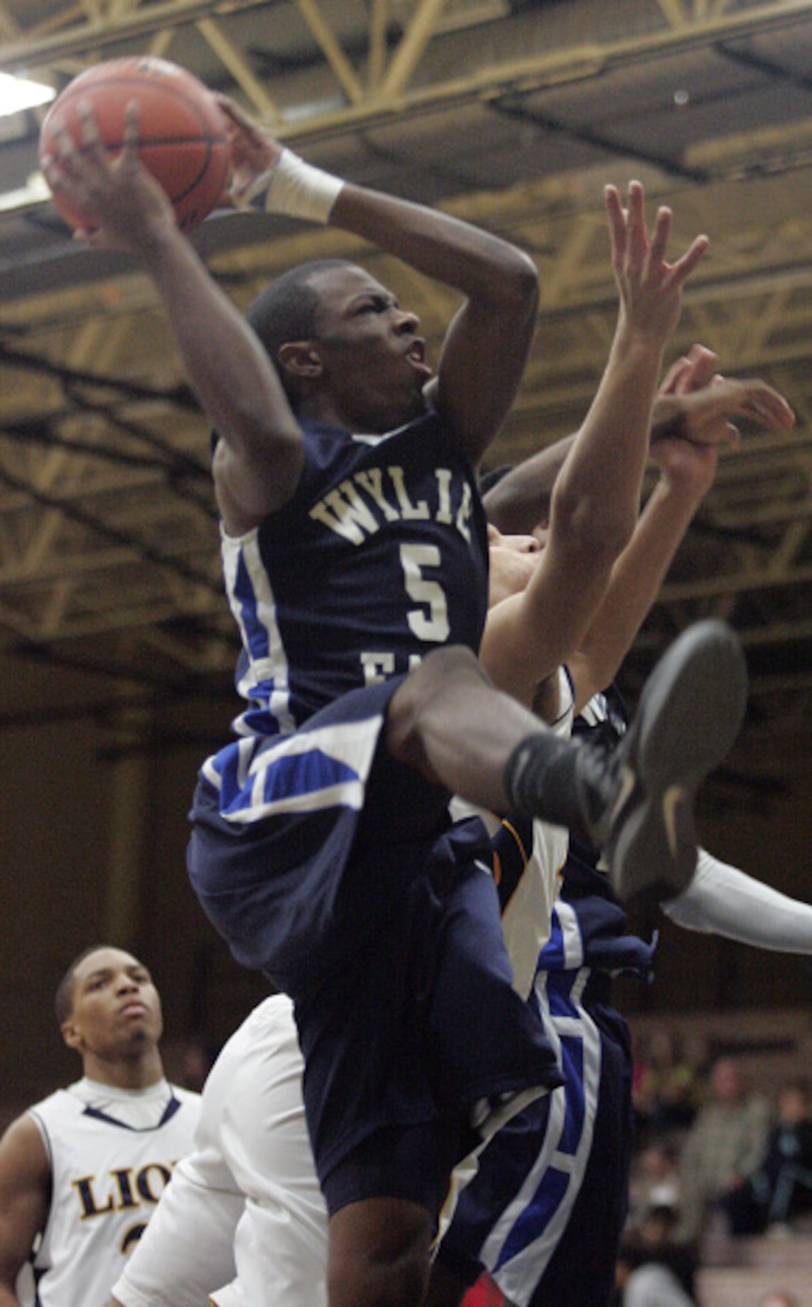 Wylie East High School's Quincy Jones (5) fights to get off a shot against McKinney High...