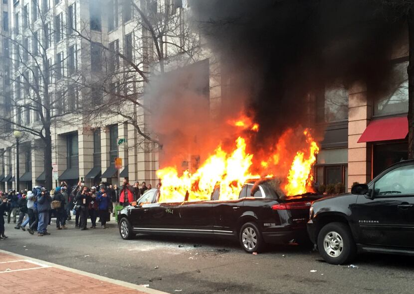 Protesters set a parked limousine on fire in downtown Washington on Friday during the...