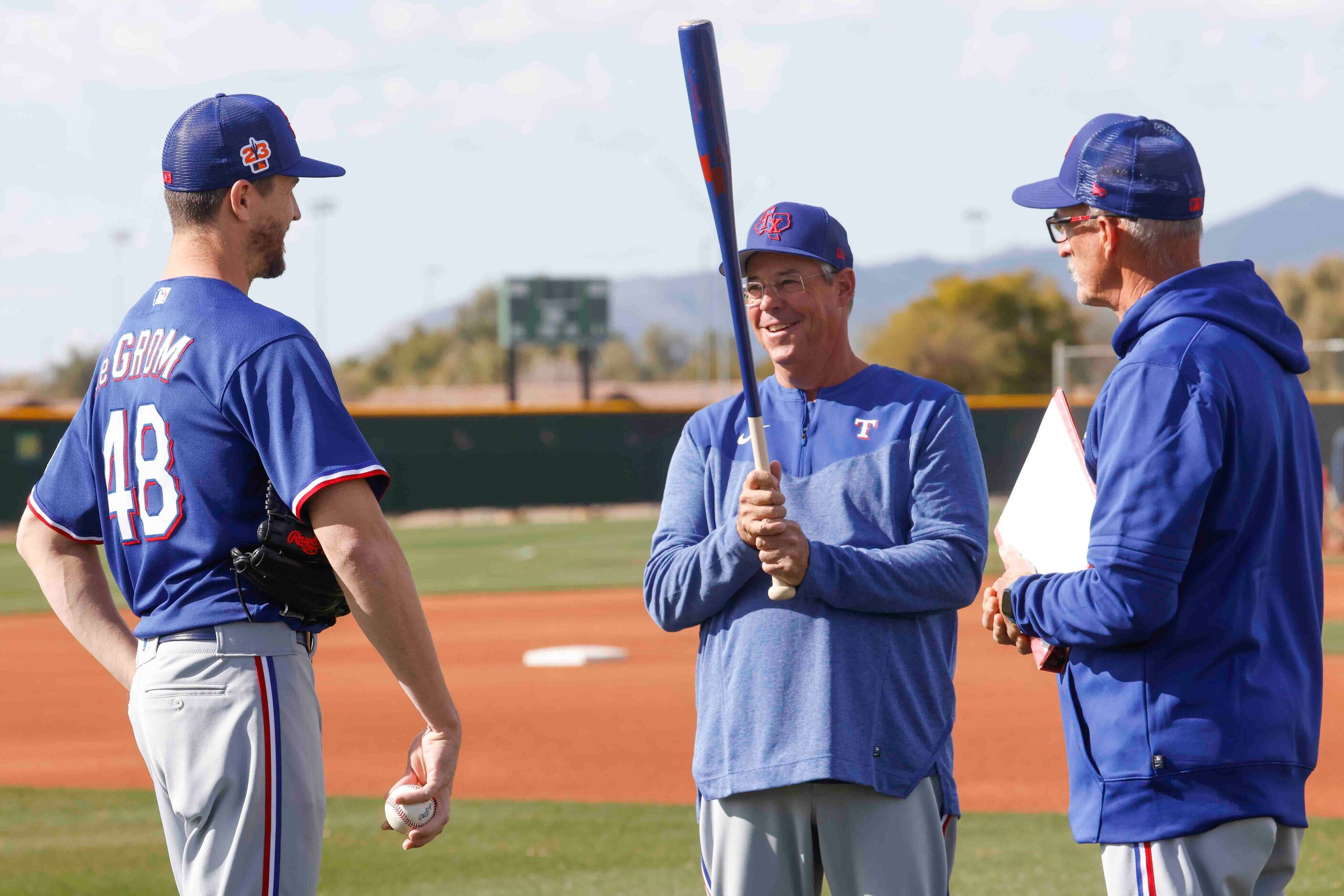 Texas Rangers pitcher Jacob deGrom, left, talks to special assistant Greg Maddux, center,...