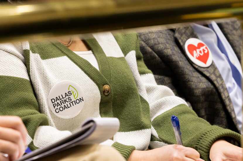 Members of the public wear a Dallas Parks Coalition and Arts pin as they seek more funding...