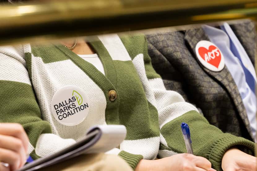 Members of the public wear a Dallas Parks Coalition and an Arts pin as they seek more...