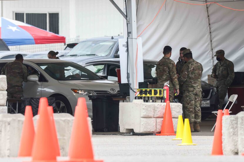 Army staff attend people receiving the COVID-19 vaccine at Fair Park in Dallas on Friday,...