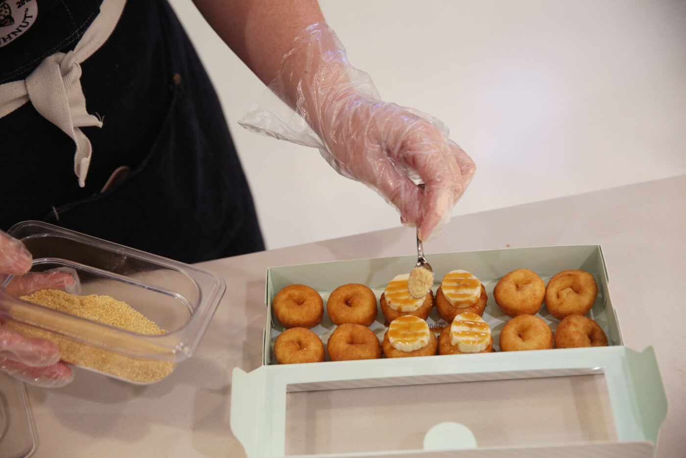 Brooke Sanchez prepares Banana Foster doughnuts at The Dapper Doughnut.