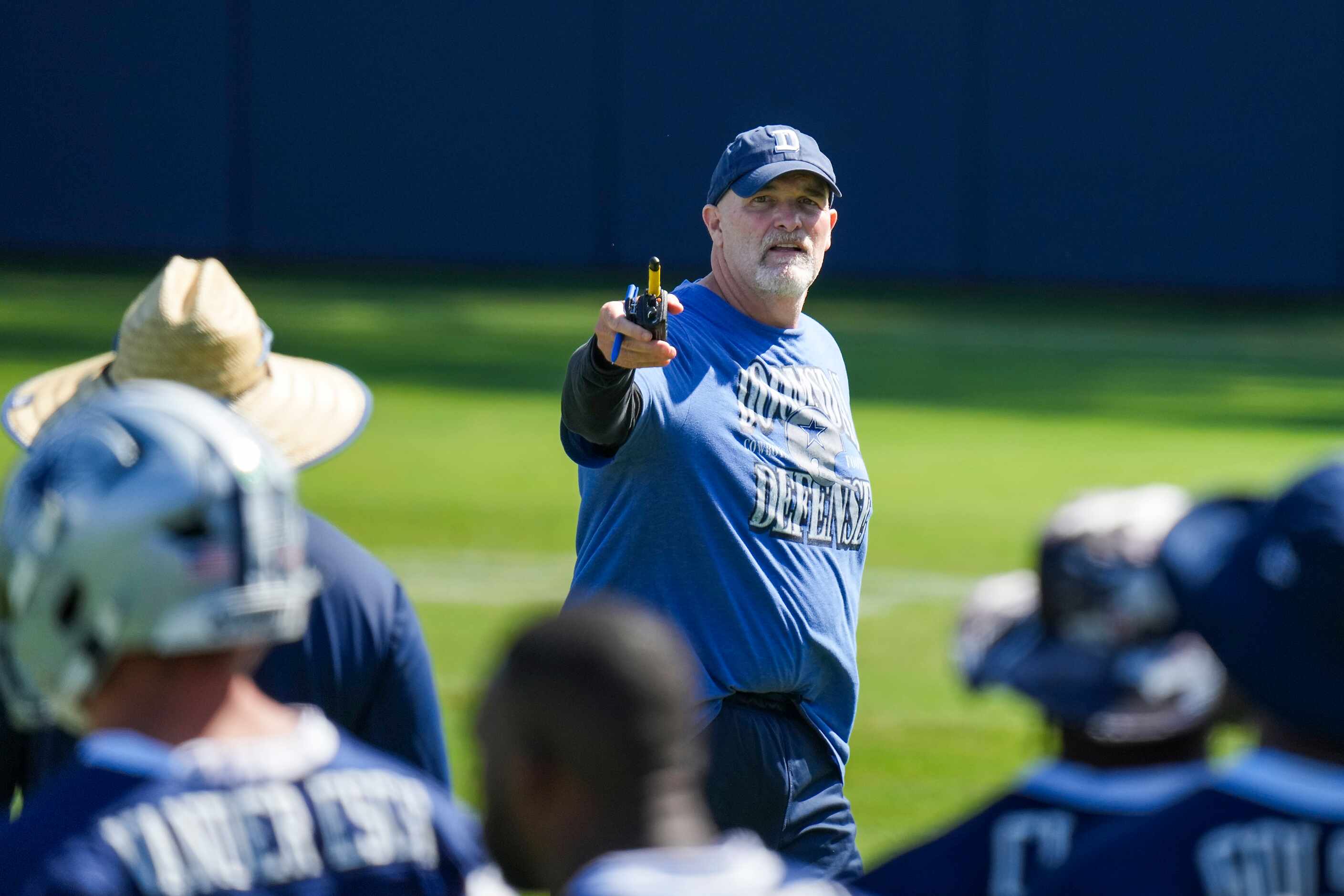Dallas Cowboys defensive coordinator Dan Quinn works with his players during a training camp...