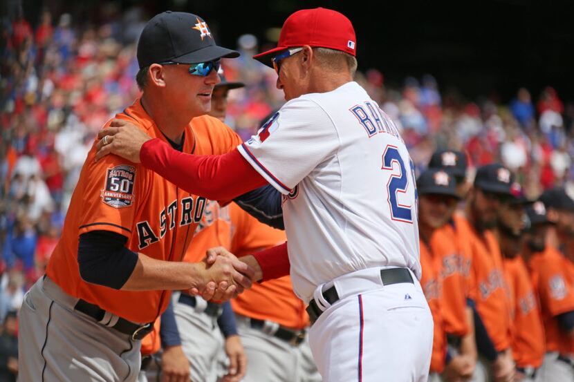 Texas Rangers manager Jeff Banister (28) shakes hands with Houston Astros manager A.J. Hinch...