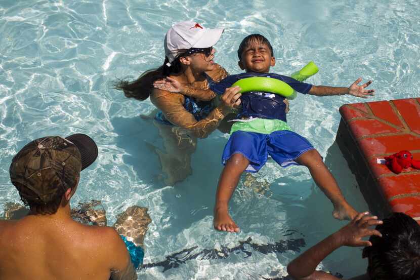 Elizabeth Cisneros, a YMCA swimming instructor, teaches Ridham Babel, 4, how to float on his...
