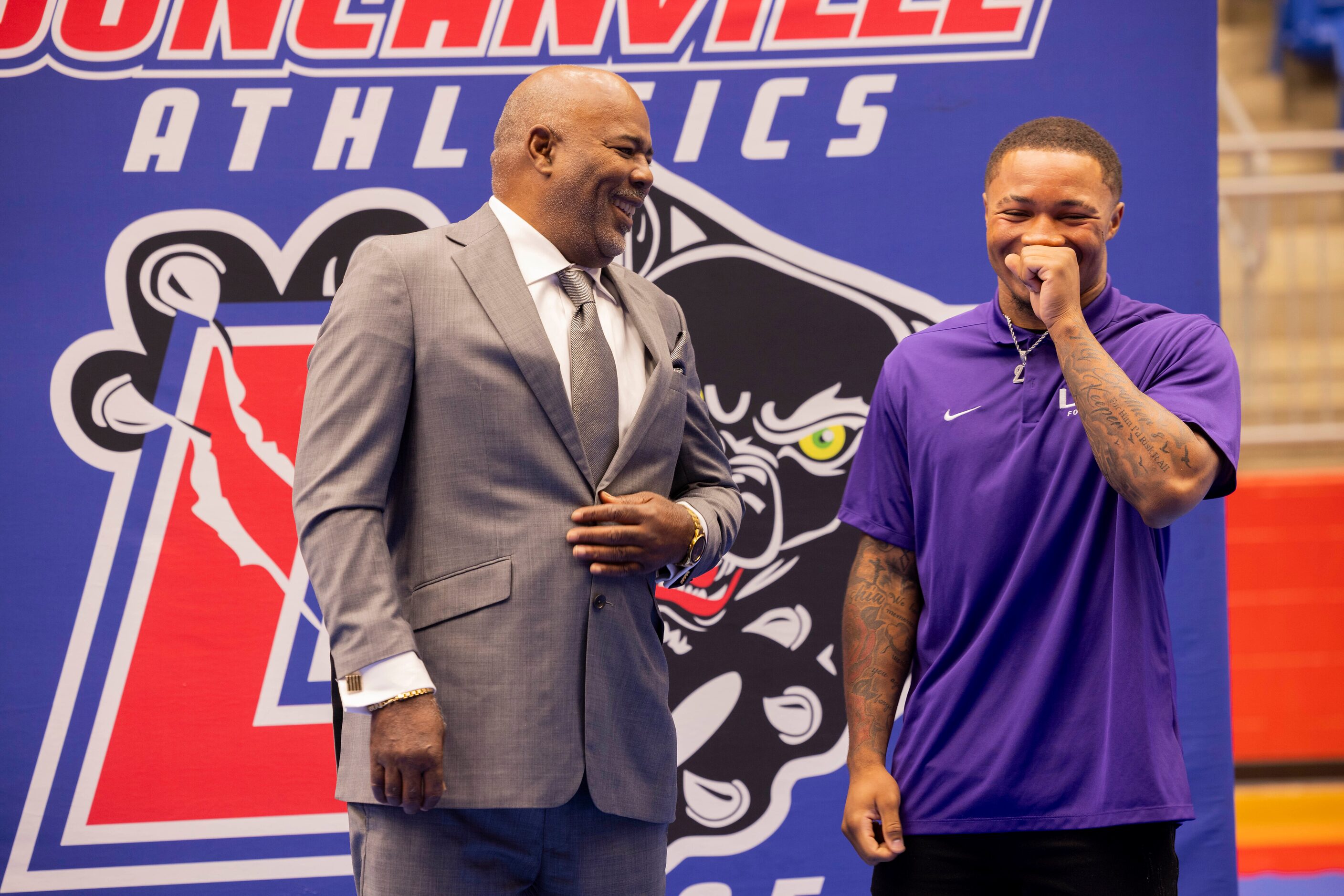 Head football coach Reginald Samples jokes with running back Caden Durham after Durham...