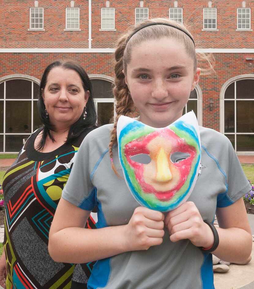 
Raine Cockrell holds a mask painted on the outside to represent how she presents herself to...