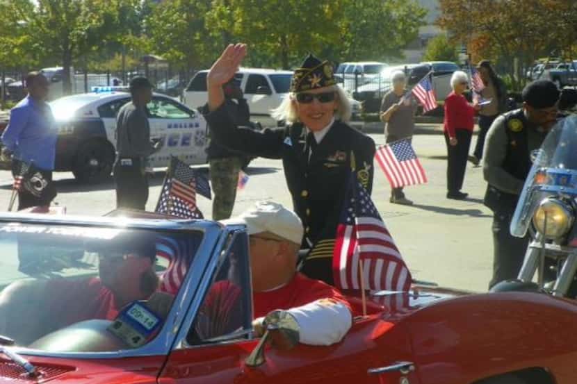 Commander Mary East of American Legion Post 597 waves to the crowd during the Veteran’s Day...