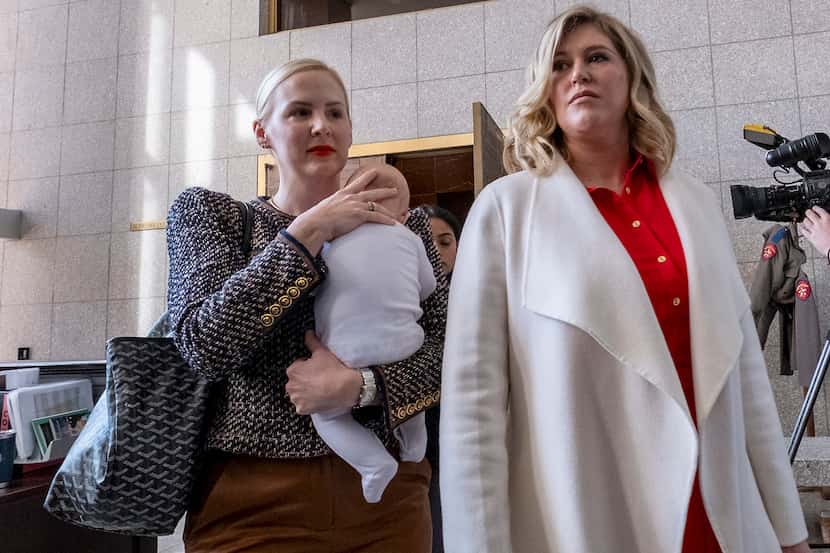 Plaintiffs Austin Dennard, an OB-GYN, holding her son, and Lauren Miller, of Dallas, along...