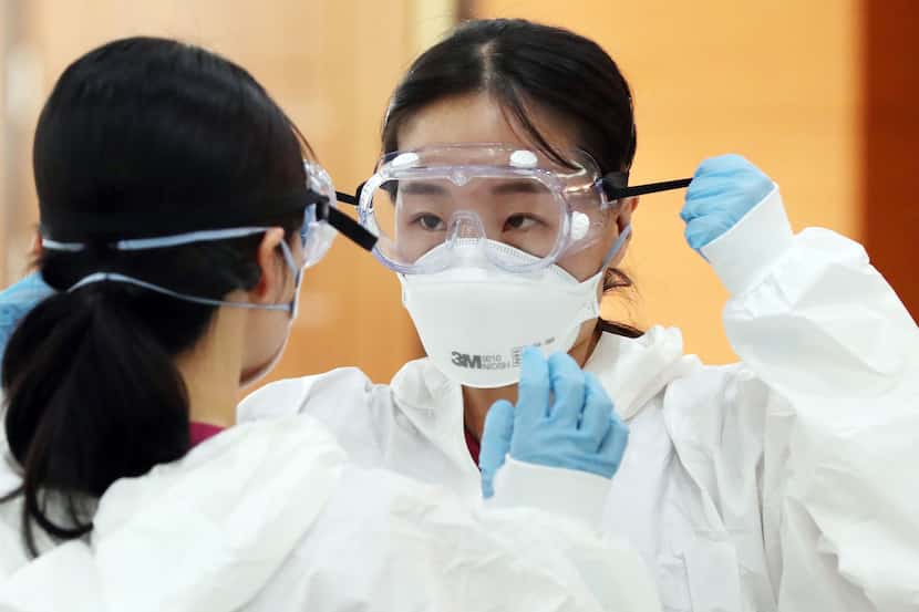 Nurses in South Korea are trained on protective equipment before treating patients who have...