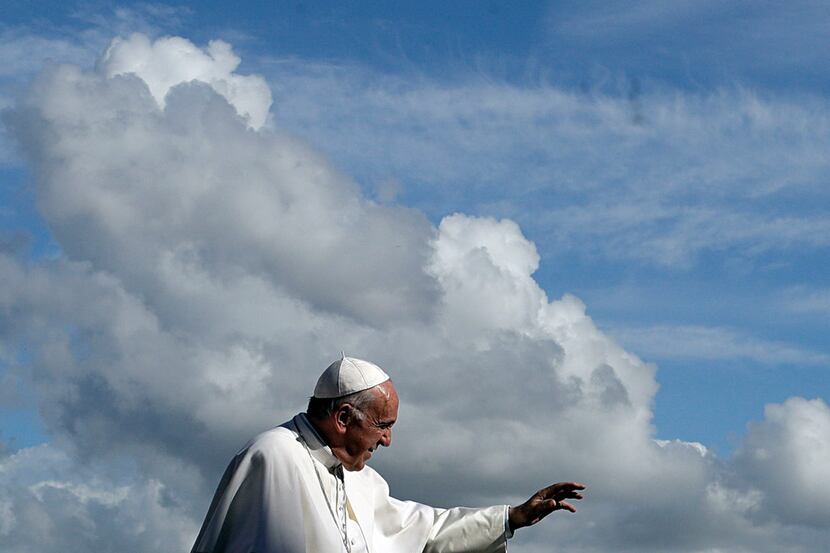 Pope Francis delivers his blessing as he leaves at the end of his weekly general audience in...