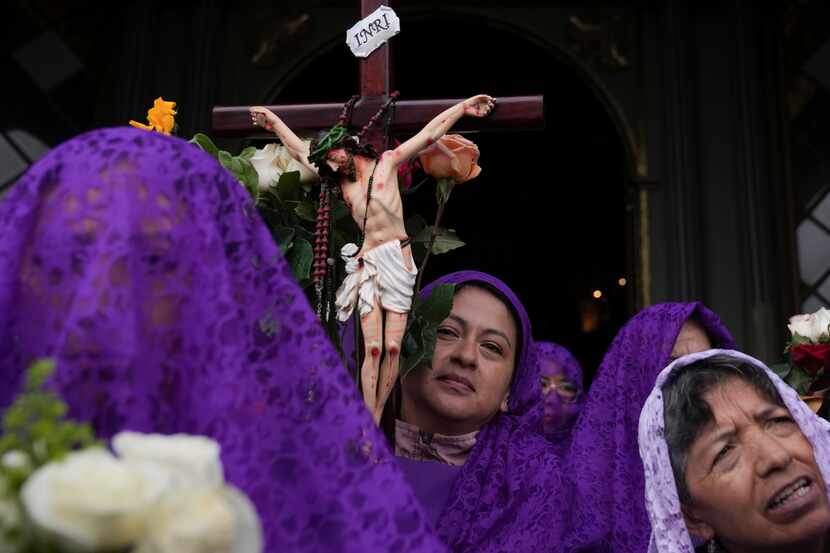 Ecuador: Penitentes cargan un crucifijo durante la procesión de Viernes Santo en Quito,...