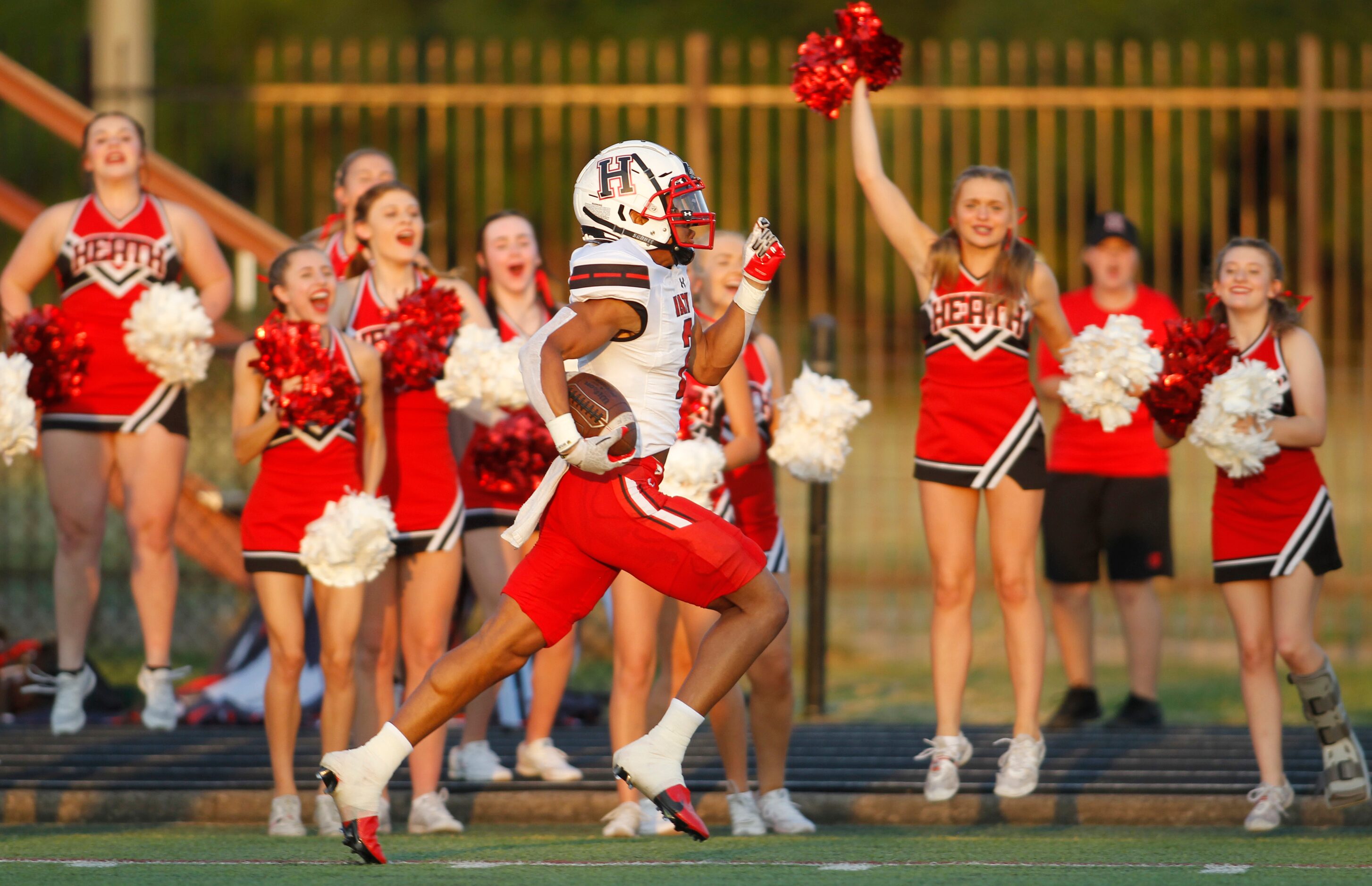 Rockwall Heath receiver Jordan Nabors (2) races past the Hawks cheerleaders enroute to his...