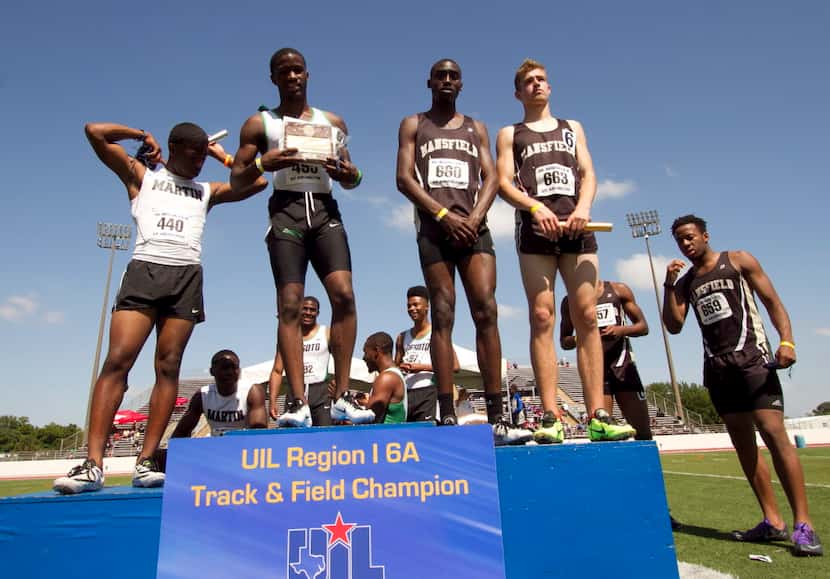 Members of the Class 6A Boys 4X100 relay team assemble for a photo at the winners stand...