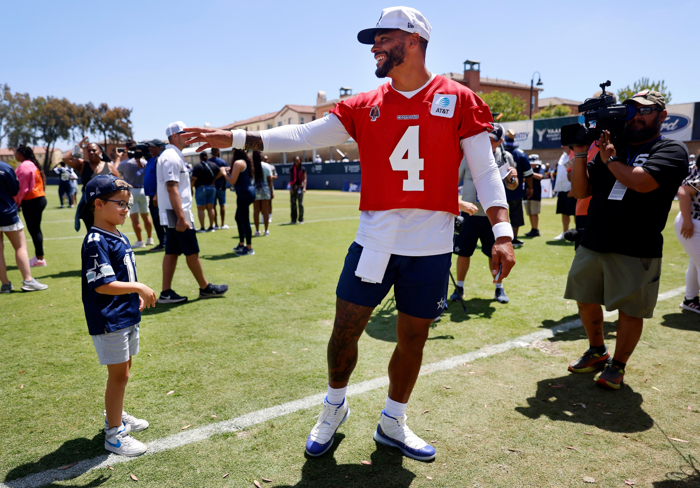 Dallas Cowboys quarterback Dak Prescott (4) shakes hand with a young fan following a...