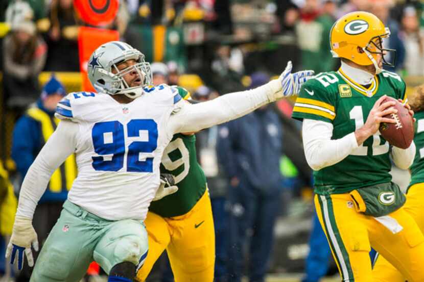 Green Bay Packers quarterback Aaron Rodgers (12) slips away from Dallas Cowboys defensive...