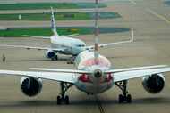 American Airlines planes push back from the gates of Terminal D at DFW Airport on Tuesday,...