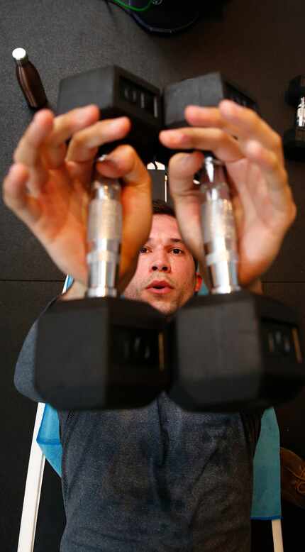 Bryan Johnson lifts weights on a surfboard at City Surf in Dallas.