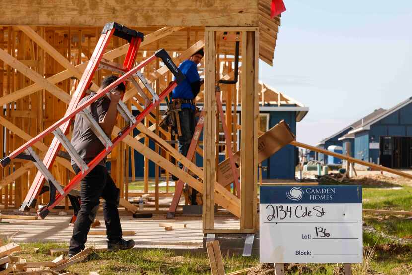 Construction workers work in a housing development by Camden Homes Nov. 22 in Mabank . 