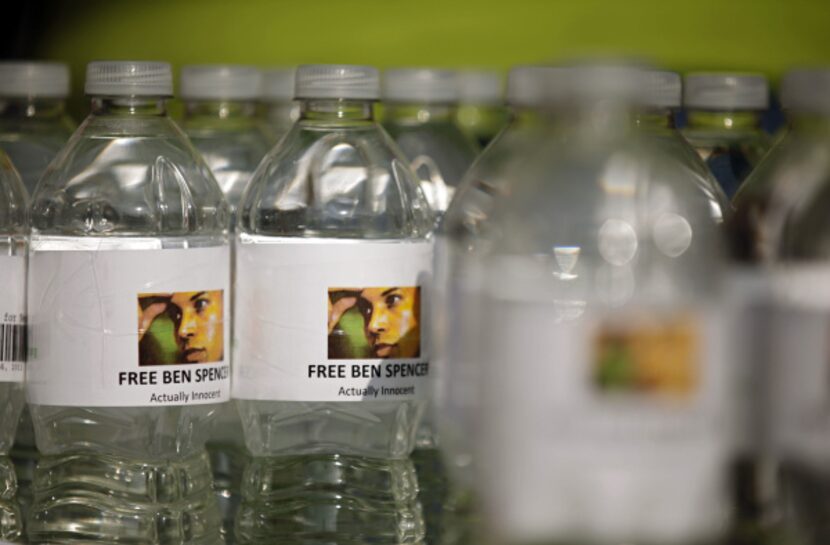 Water bottles bear a likeness of Ben Spencer during a rally in his honor .