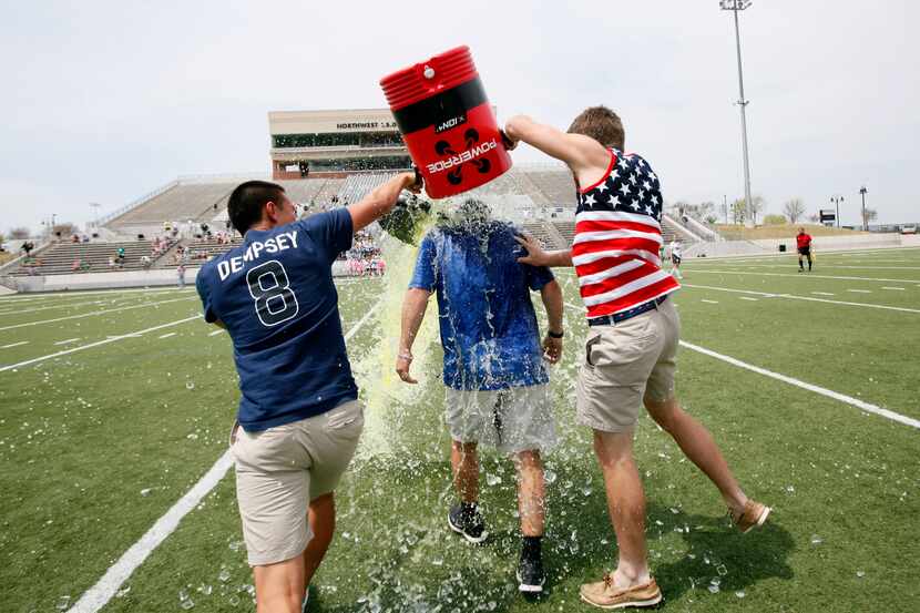 Hebron seniors Joel Carlos, left, and Tyler Zych, dump a water cooler of Gatorade and ice on...
