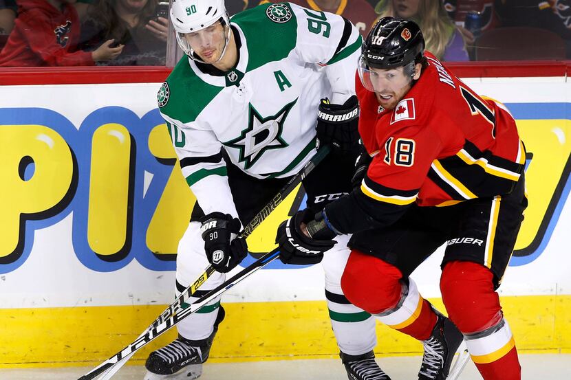 Dallas Stars center Jason Spezza (90) and Calgary Flames left wing James Neal (18) watch the...
