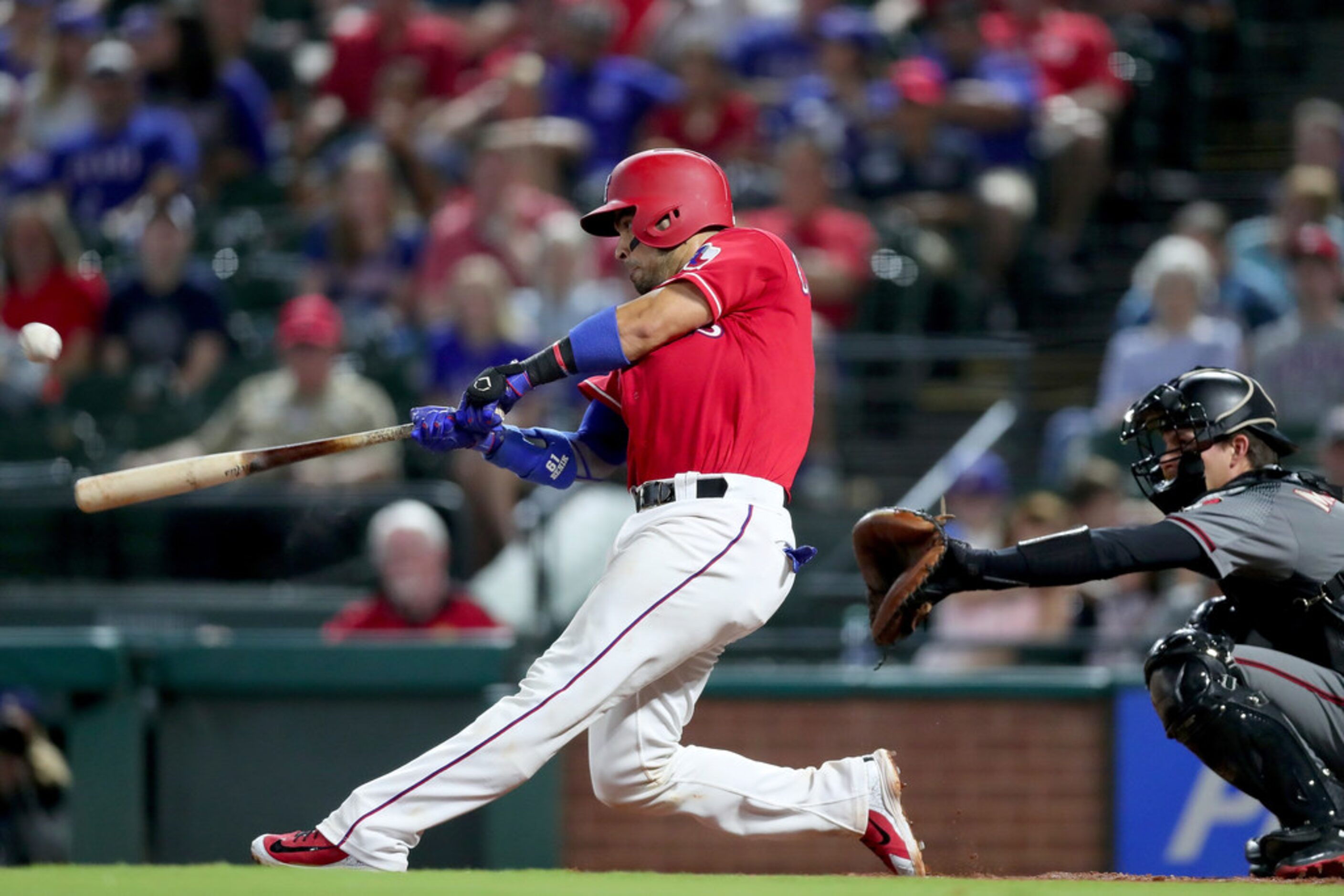 ARLINGTON, TX - AUGUST 13:  Robinson Chirinos #61 of the Texas Rangers hits a RBI single...