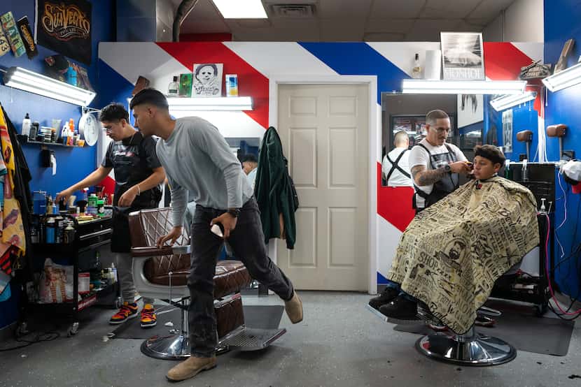 Barber Edgar "E" Montelongo, 35 (right) prepared to give Nathan Cabrera, 12 an Edgar cut at...