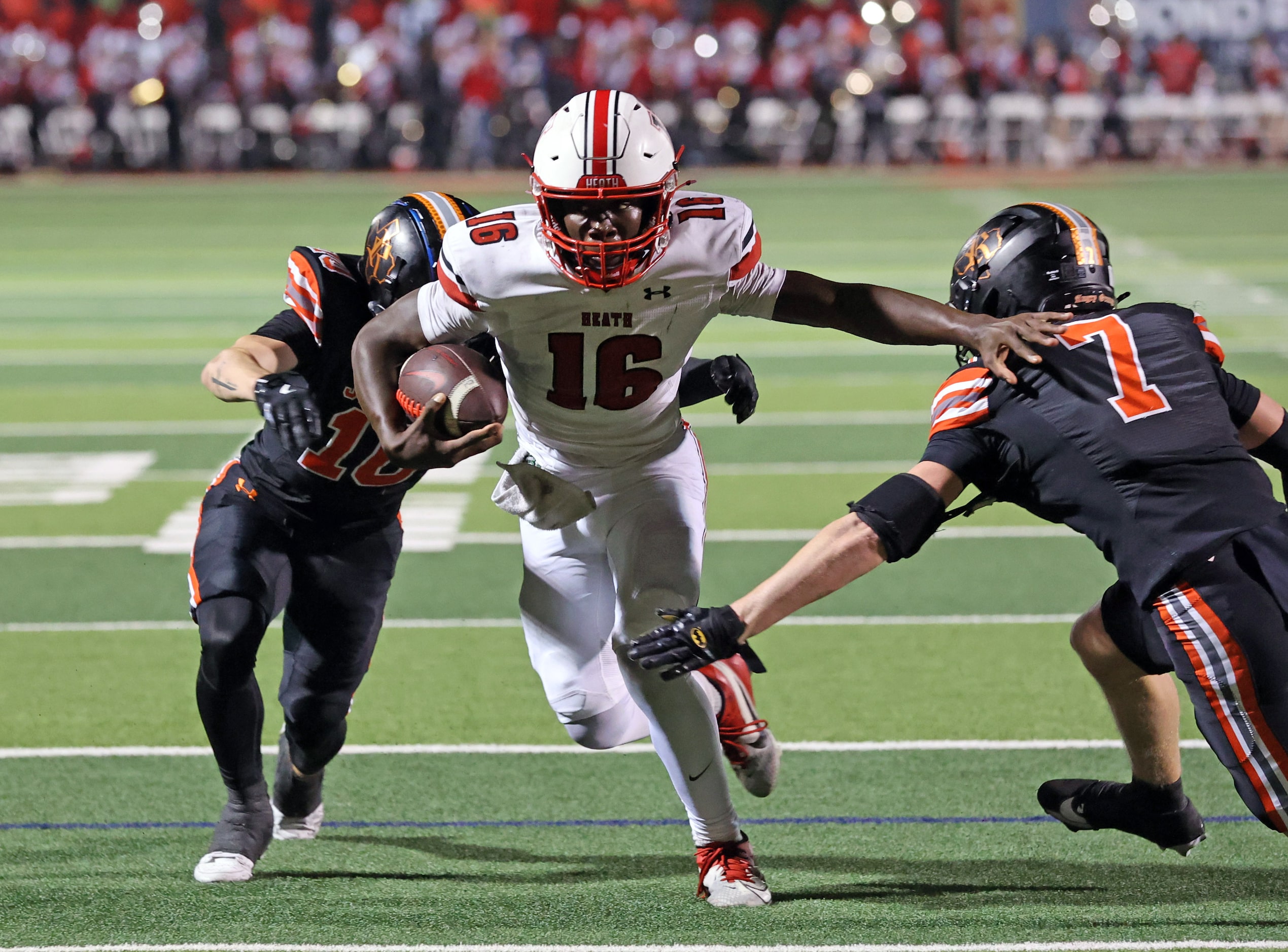 Rockwall Heath High QB Prosper Neal (16) tries, but can’t get past, Rockwall defenders Kaden...