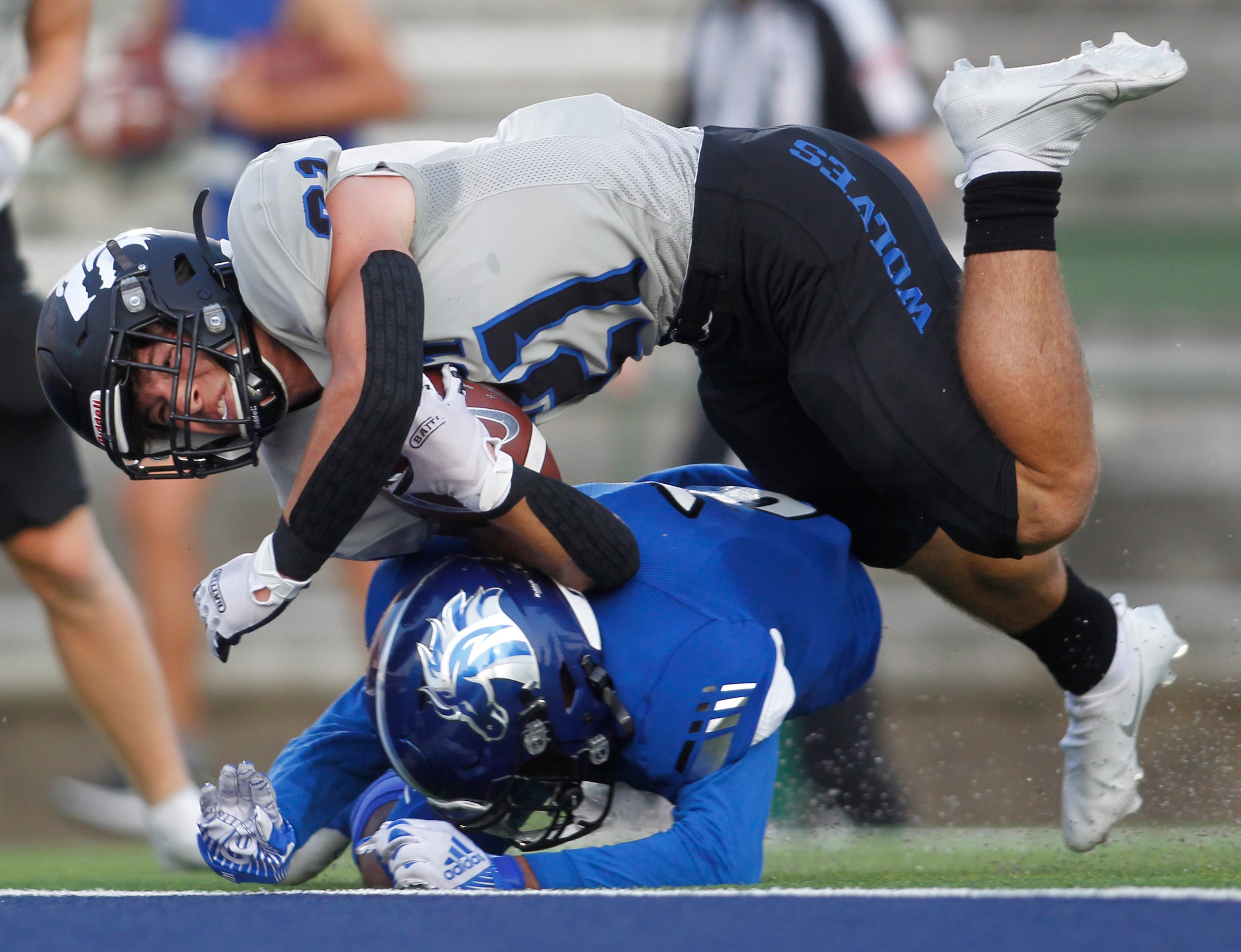 Plano West running back Dermot White (21) dives over North Mesquite's Da'lan Hicks (3)...