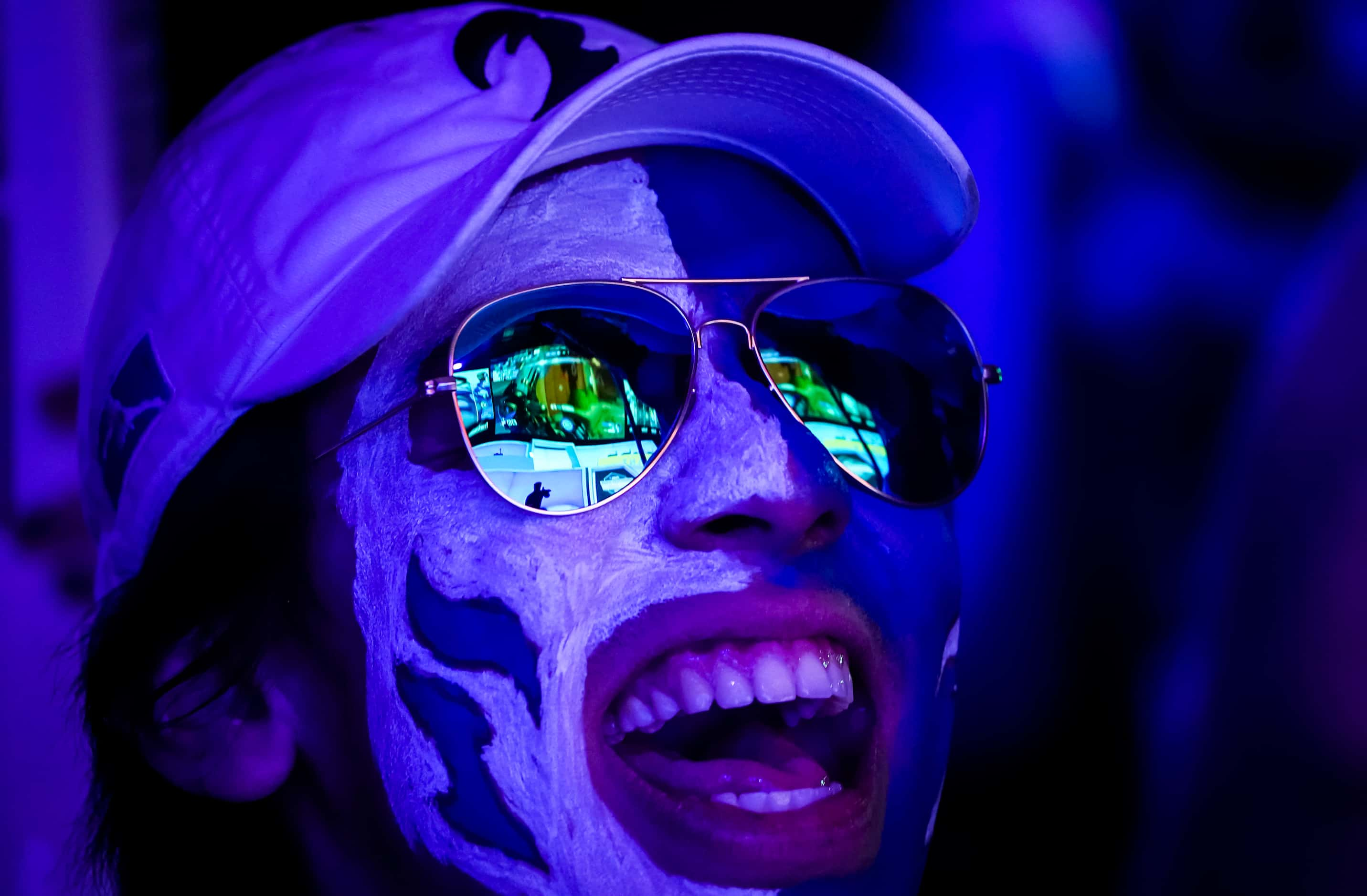 The competition stage is reflected in his glasses as Dallas Fuel fan Andrew Diaz cheers his...