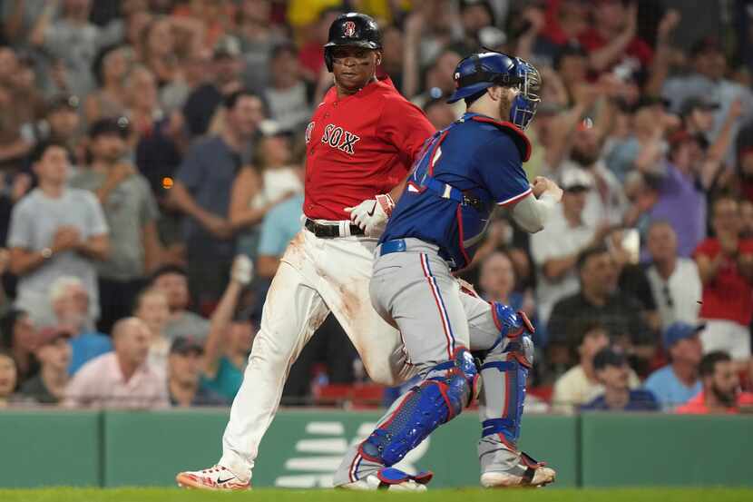 Boston Red Sox's Rafael Devers, left, scores near Texas Rangers' Jonah Heim, right, on a...