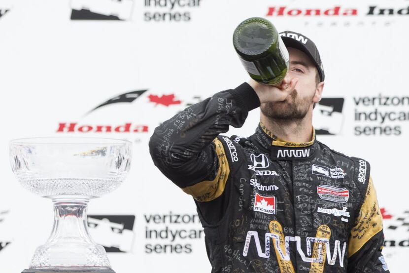 Canadian Driver James Hinchcliffe drinks champagne as he celebrates his third place finish...