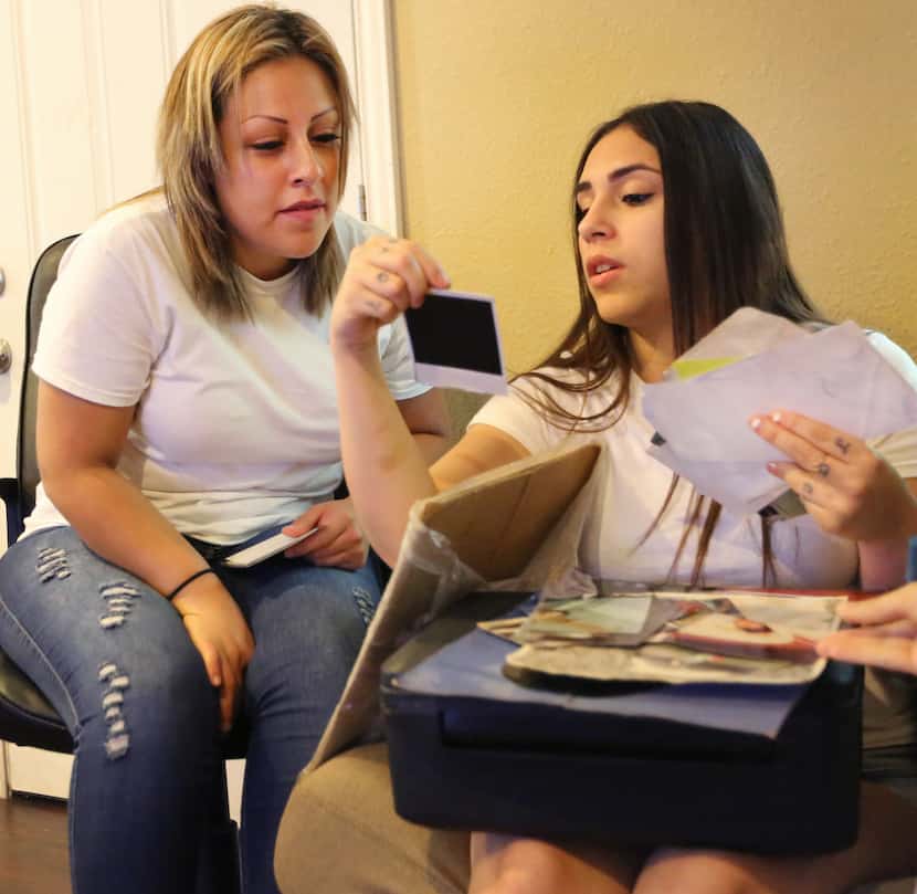 Daisy Serrano (right) looks at family photos with her cousin Dulce Dominguez. Daisy's...