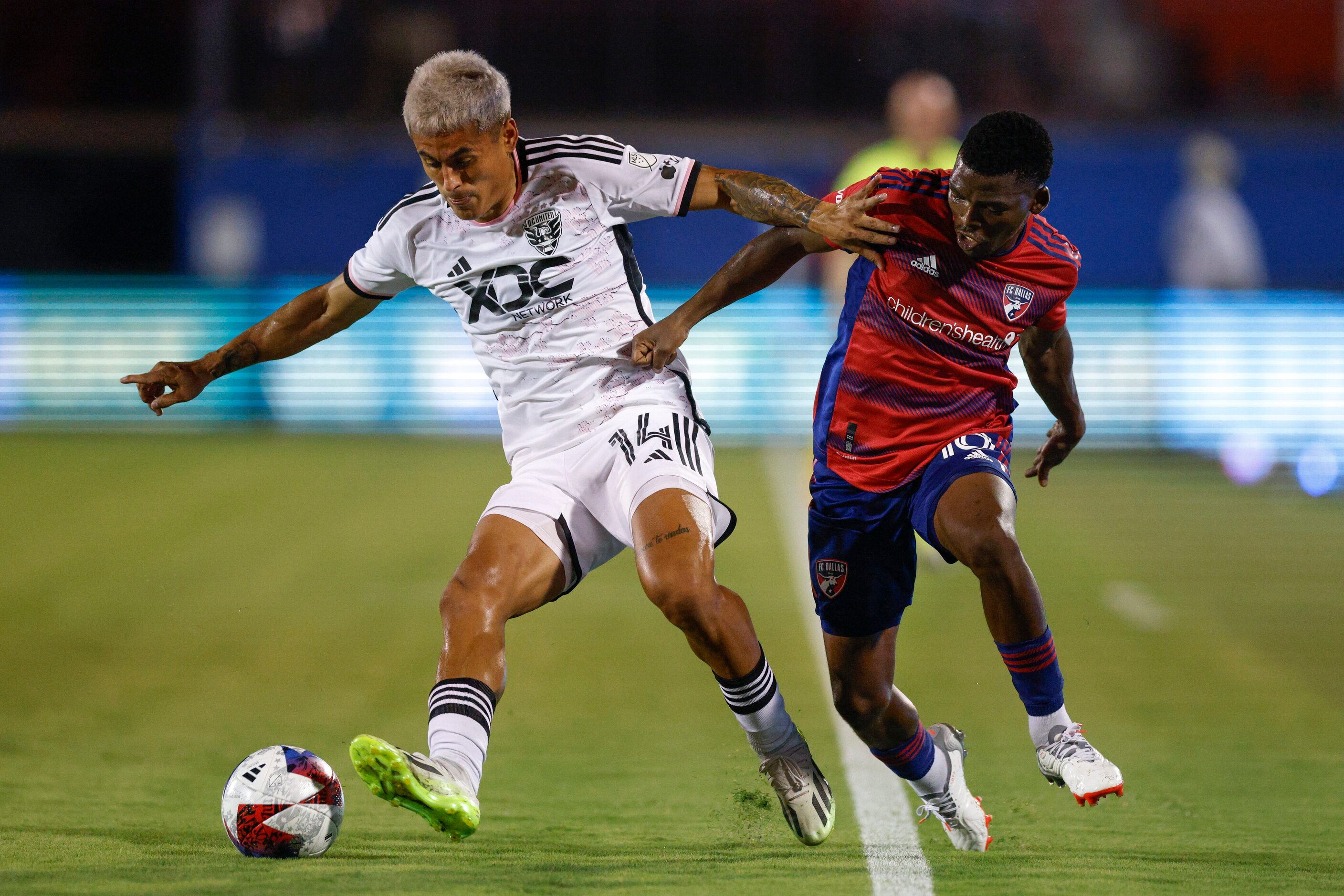 D.C. United midfielder Andy Najar (14) and FC Dallas forward Tsiki Ntsabeleng (16) battle...