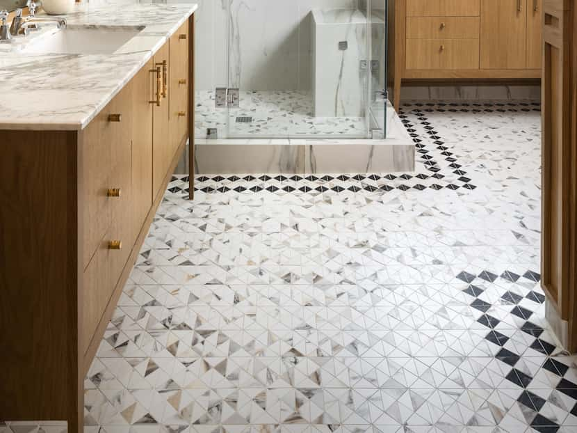 Bathroom with tiled floors, honey-hued wood cabinets and a white marble shower