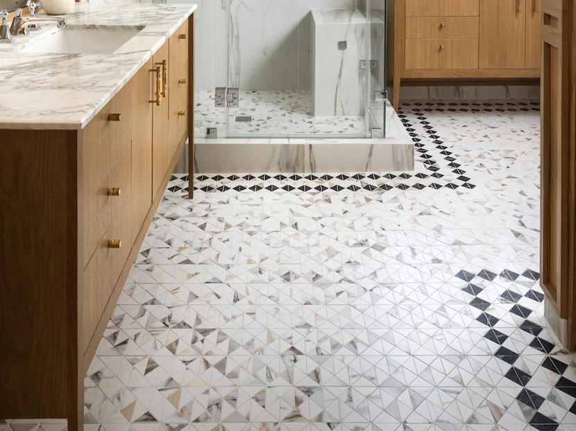 Bathroom with tiled floors, honey-hued wood cabinets and a white marble shower