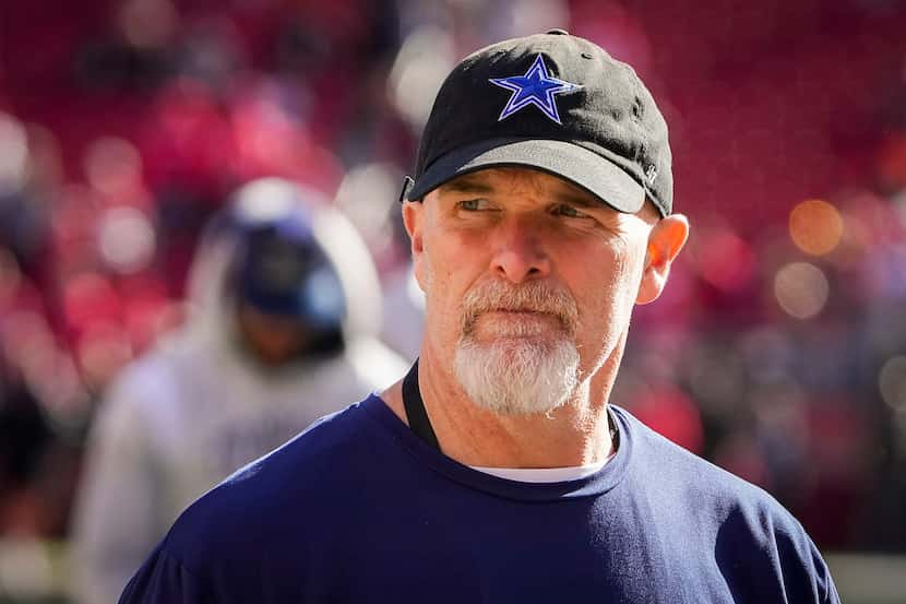 Dallas Cowboys defensive coordinator Dan Quinn watches as the teams warm up before an NFL...