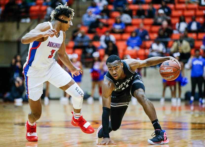 Denton Guyer senior guard De'Vion Harmon, right, looks for room against Duncanville senior...