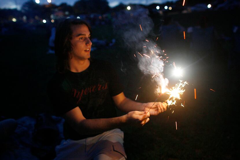 Jimmy Wilkins lights sparklers prior to Independence Day fireworks at Harry Myers Park in...