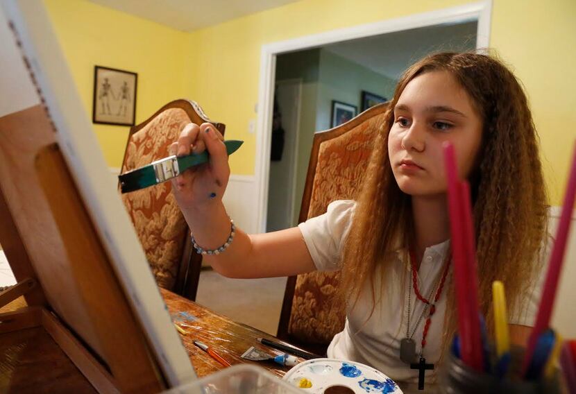 Alexis Brown, 11, concentrates on a painting at home in Denison, Texas, Tuesday April 4,...