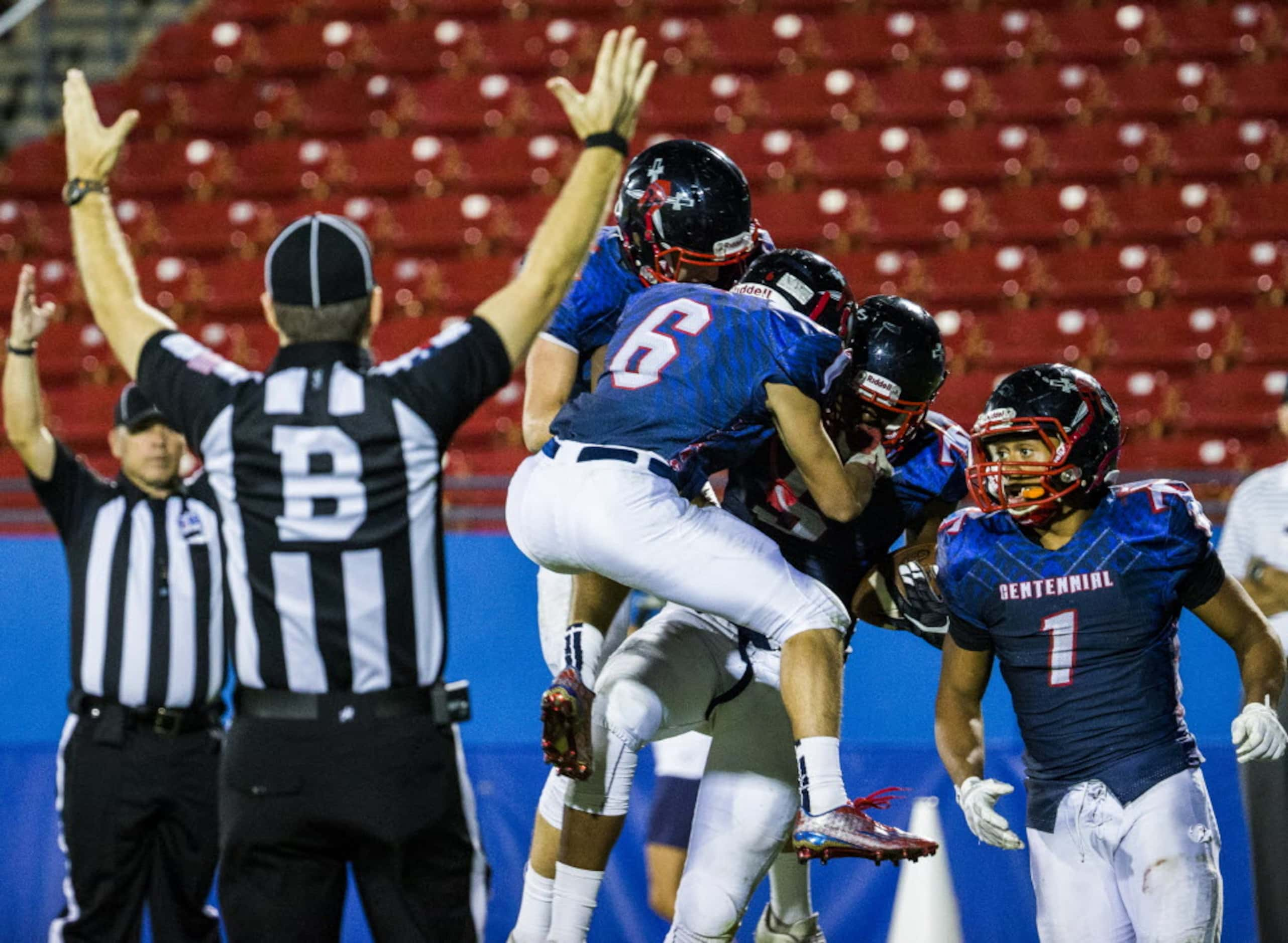 Frisco Centennial players celebrate with Frisco Centennial wide receiver Kenny Nelson (5)...