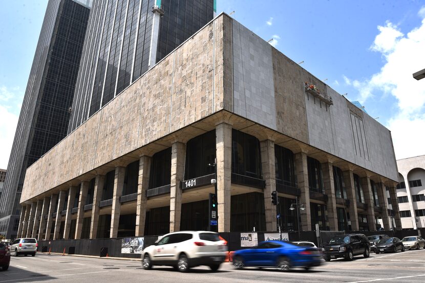 Construction workers use a scaffold to install marble on the First National Bank buildings...