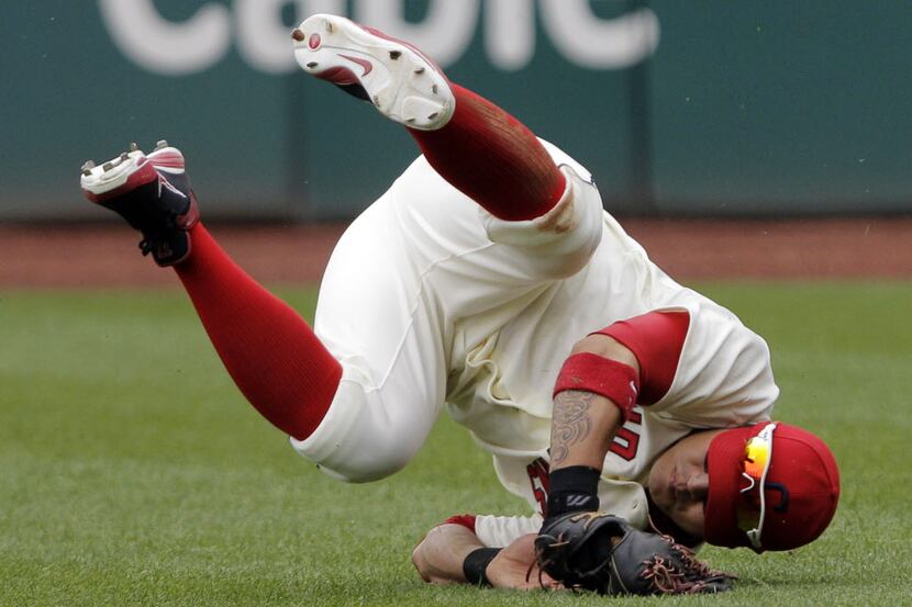 Cleveland Indians right fielder Shin-Soo Choo rolls upside down after catching a fly ball by...